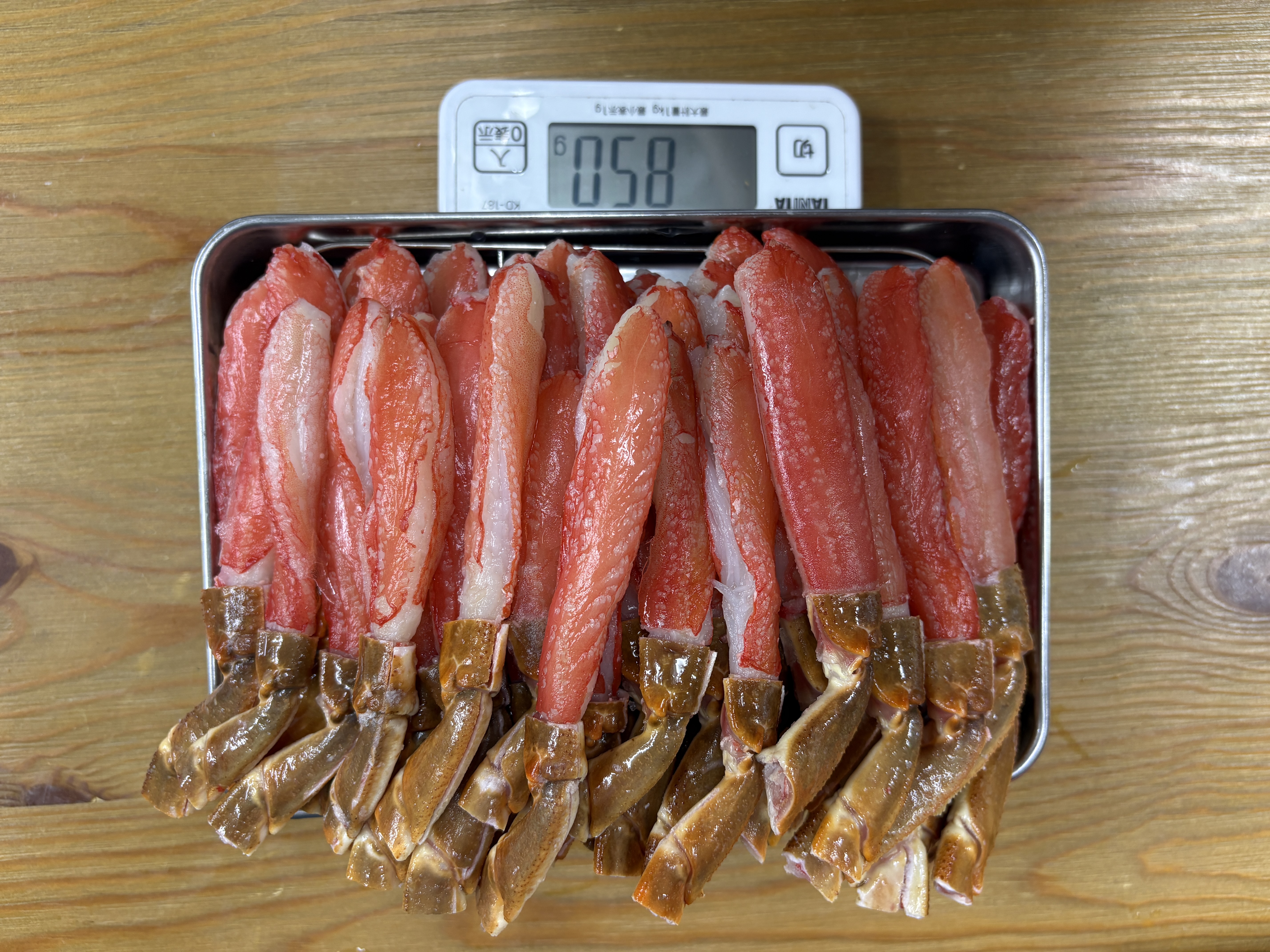 解凍後の生ズワイ脚肉むき身をトレーに並べて量った写真