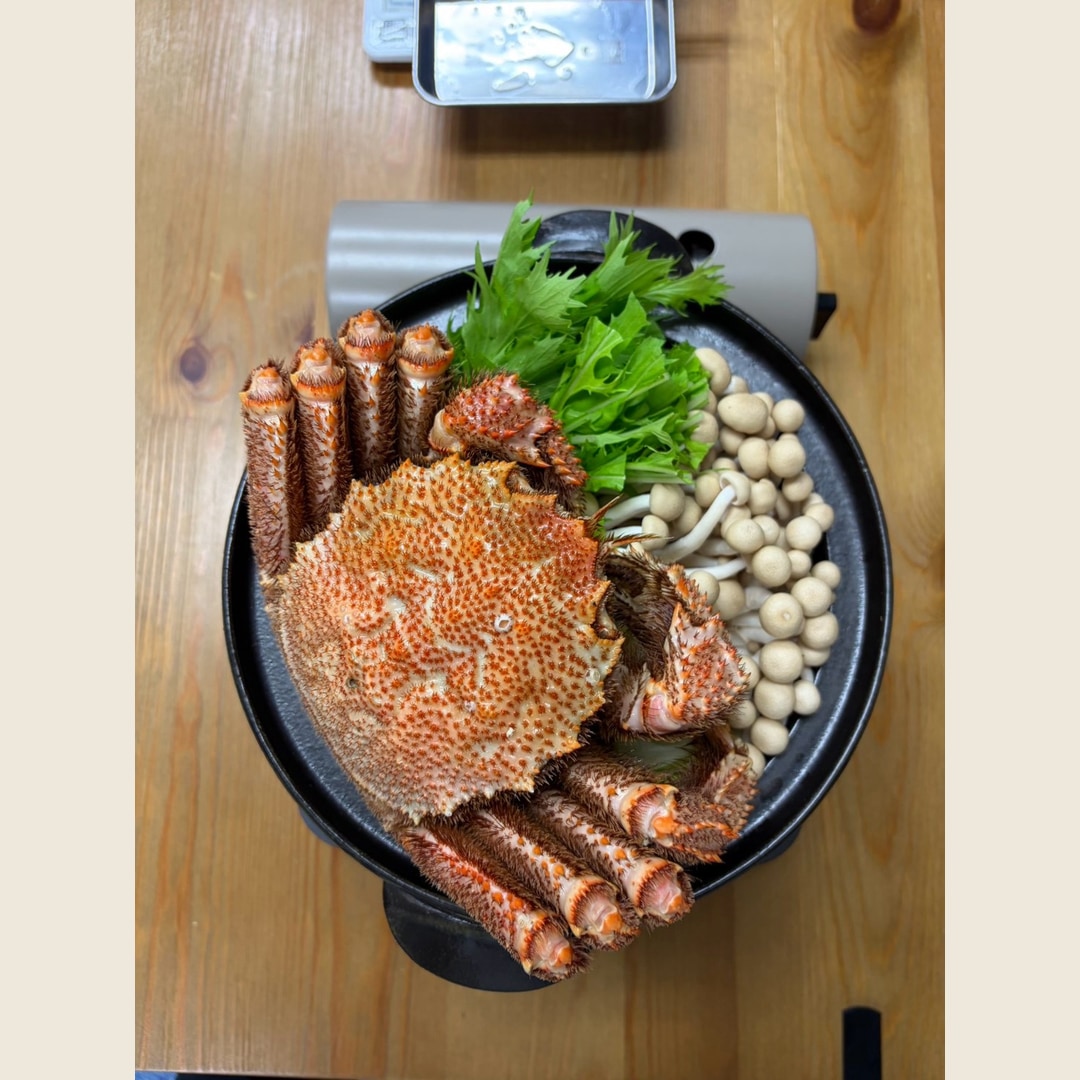 野菜ときのこの鍋に姿のまま載せた、編集部購入の特大毛ガニ