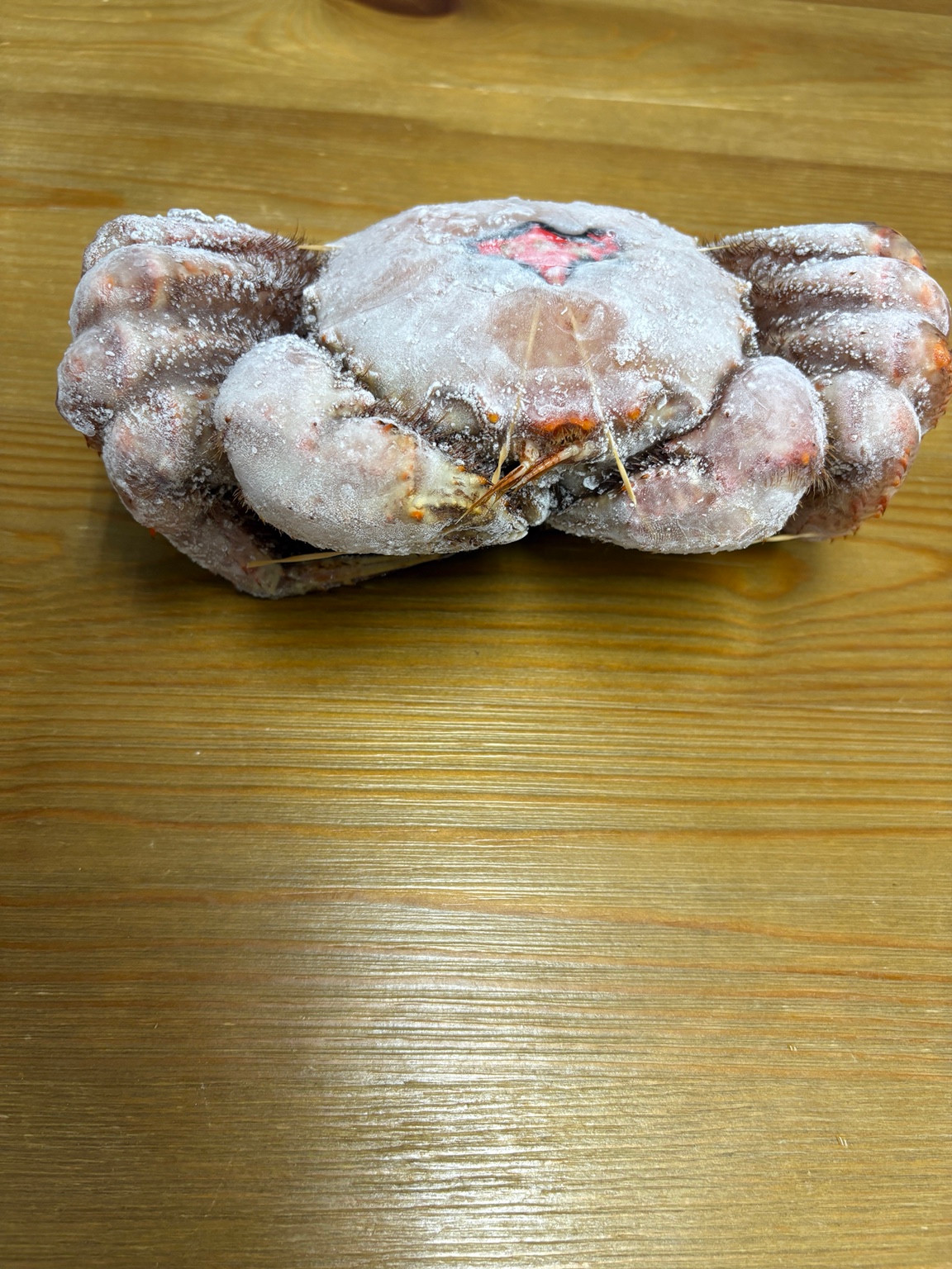 表面に氷の膜が付いた冷凍状態の特大毛ガニ