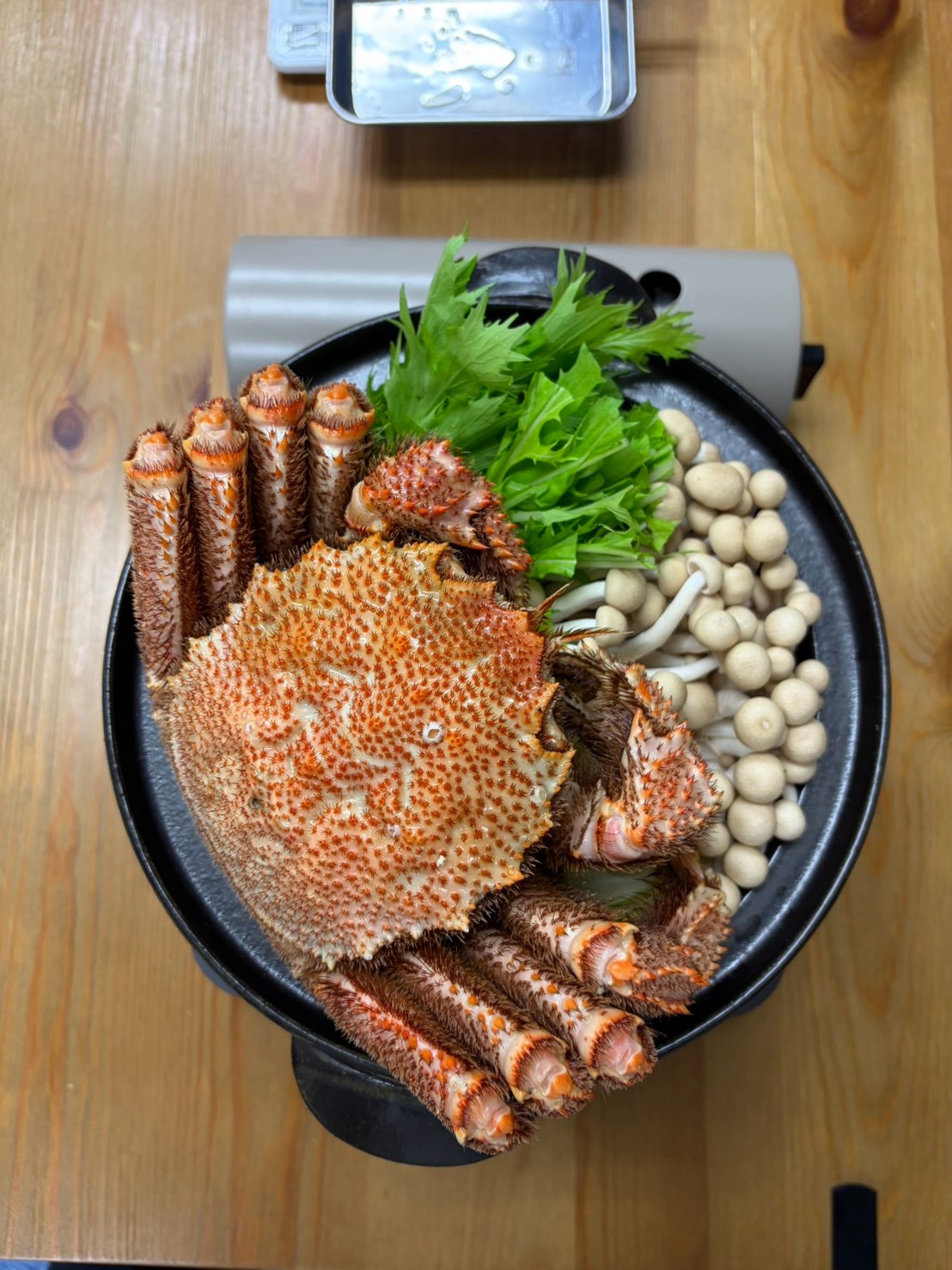 野菜ときのこの鍋に姿のまま載せた、編集部購入の特大毛ガニ