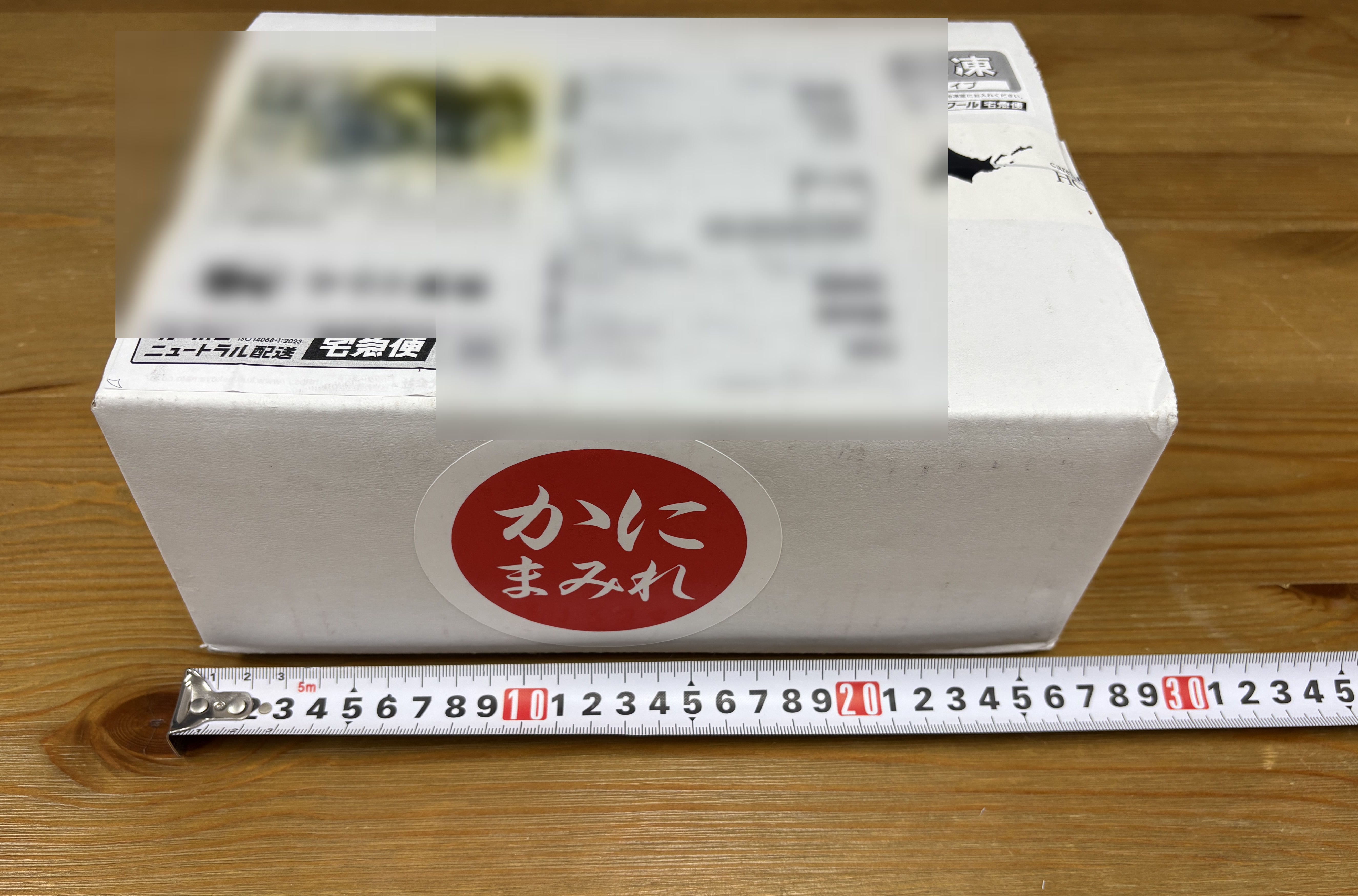 配送ラベルを判読できないよう加工した、かにまみれの白い保冷外箱